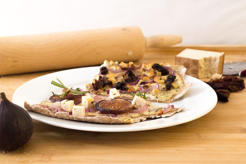 Ein unheimlich leckeres und besonderes Rezept für Flammkuchen: Mit frischen Feigen, veganem Schmand und "Feta"-Tofu, roten Zwiebeln und Rosmarin. Oder doch lieber die eher klassische Variante mit Räuchertofu und Tomaten? Klick dich gleich zum Rezept - wie immer komplett vegan.