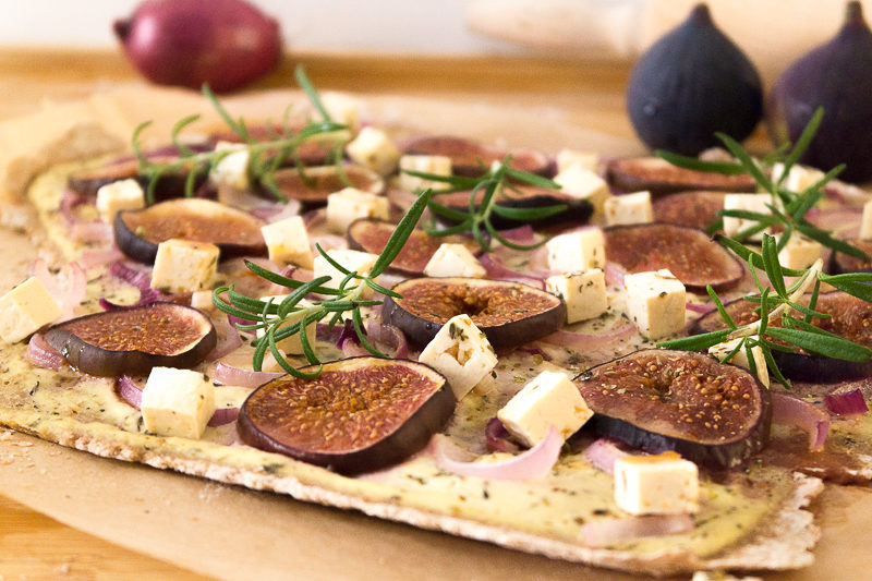 Ein unheimlich leckeres und besonderes Rezept für Flammkuchen: Mit frischen Feigen, veganem Schmand und "Feta"-Tofu, roten Zwiebeln und Rosmarin. Oder doch lieber die eher klassische Variante mit Räuchertofu und Tomaten? Klick dich gleich zum Rezept - wie immer komplett vegan.