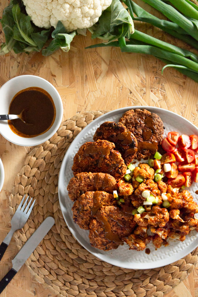 Hier treffen deftige Blumenkohlwings mit gesunden, würzigen Kidneybohnen-Bratlingen zusammen und werden mit einer leckeren Mandel-Sojasaucen-Creme garniert. Ein einfaches und gesundes veganes Rezept für ein leckeres Abendessen. Klick dich gleich zum Rezept!